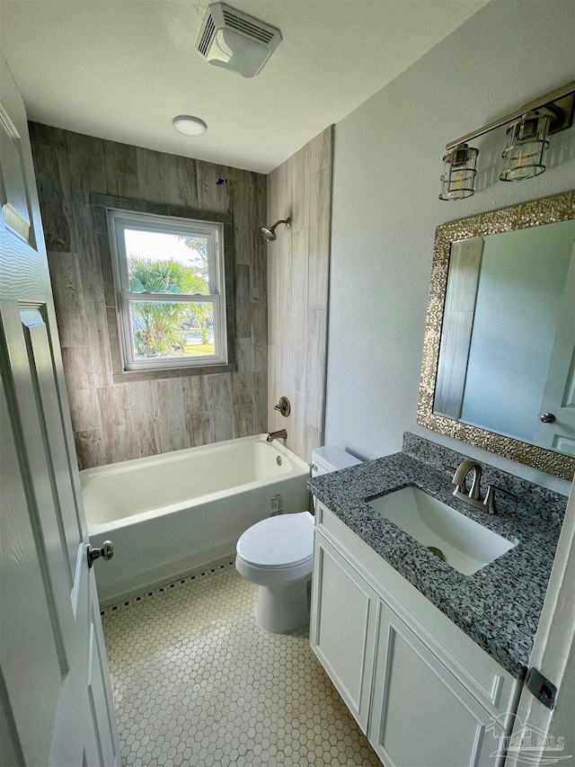 full bathroom with vanity, tile patterned floors, wooden walls, tiled shower / bath combo, and toilet