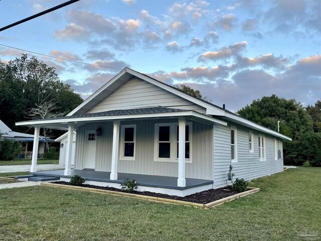 view of front facade featuring covered porch and a front yard