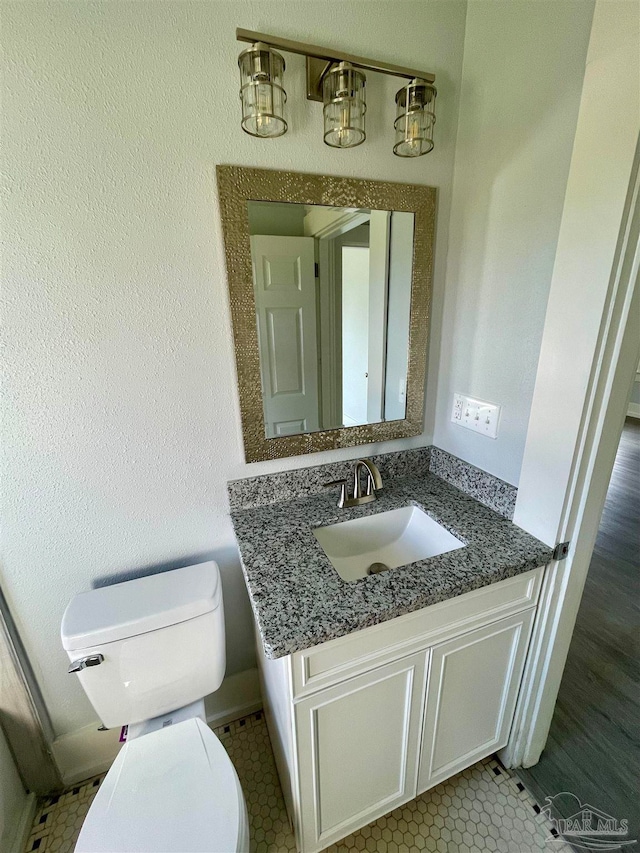 bathroom featuring vanity, tile patterned flooring, and toilet