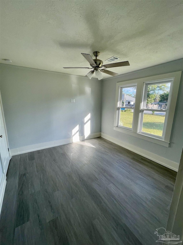 empty room featuring ceiling fan, dark hardwood / wood-style floors, and a textured ceiling