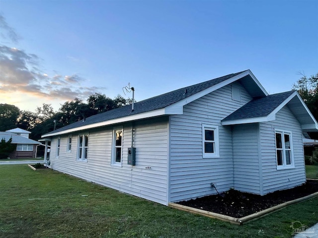 property exterior at dusk with a yard