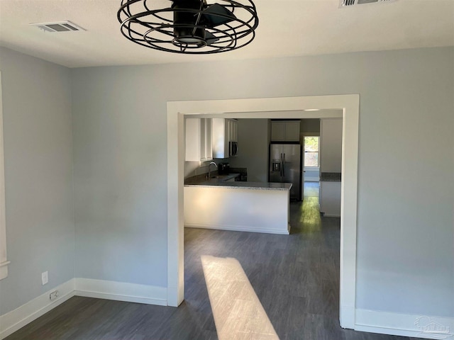 kitchen featuring stainless steel fridge with ice dispenser, dark hardwood / wood-style flooring, sink, and an inviting chandelier