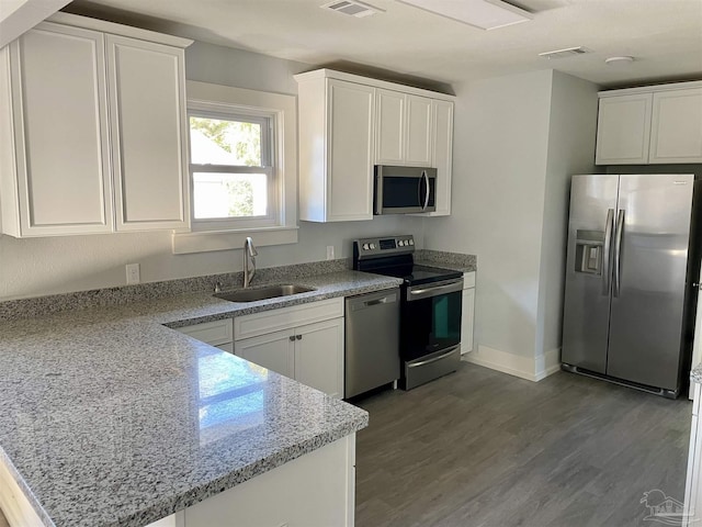 kitchen featuring sink, white cabinetry, light hardwood / wood-style flooring, stainless steel appliances, and light stone countertops