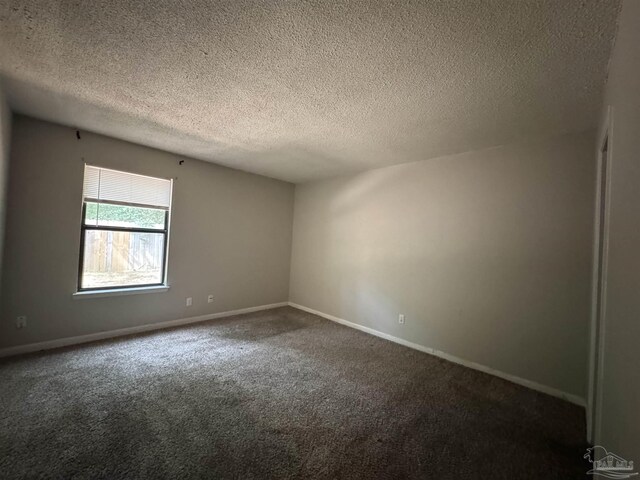 spare room featuring a textured ceiling, baseboards, and carpet