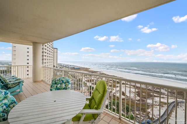 balcony featuring a beach view and a water view