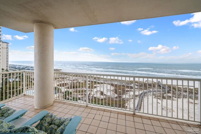 balcony featuring a beach view and a water view