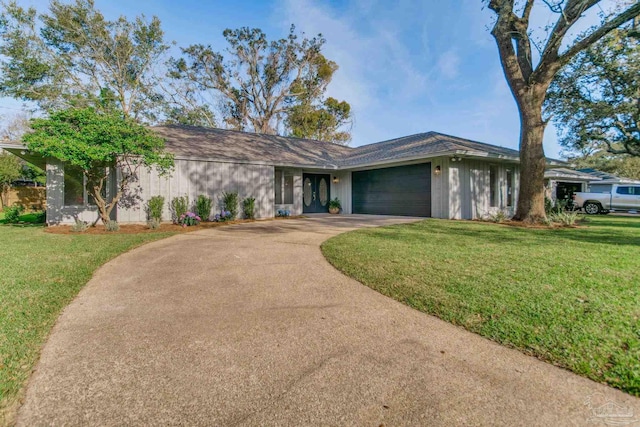 view of front of house featuring a front yard, concrete driveway, and a garage