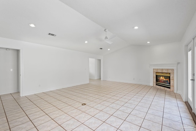 unfurnished living room featuring ceiling fan, a healthy amount of sunlight, a fireplace, and vaulted ceiling