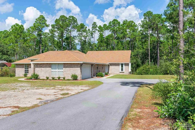 single story home featuring a garage and a front yard