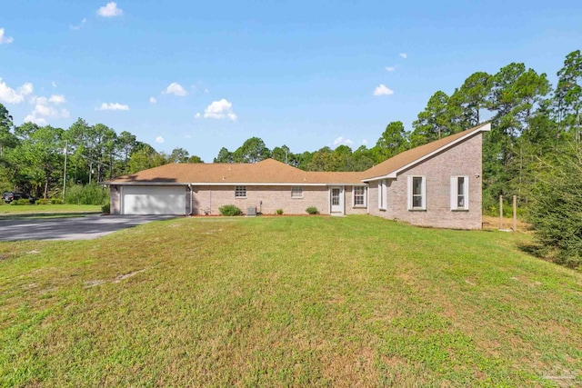 ranch-style home featuring a garage and a front lawn