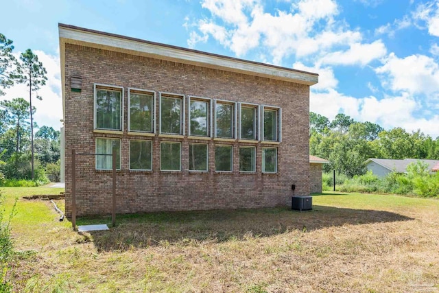 back of house featuring a yard and central AC unit