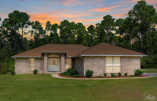 single story home with a lawn