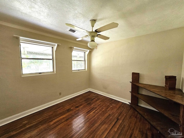 empty room with dark wood-type flooring, ceiling fan, crown molding, and a textured ceiling