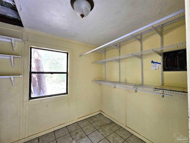 walk in closet with light tile patterned floors