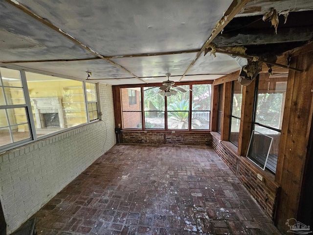 unfurnished sunroom featuring ceiling fan