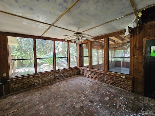 unfurnished sunroom featuring ceiling fan