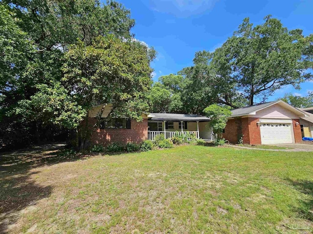 single story home featuring a porch, a garage, and a front lawn