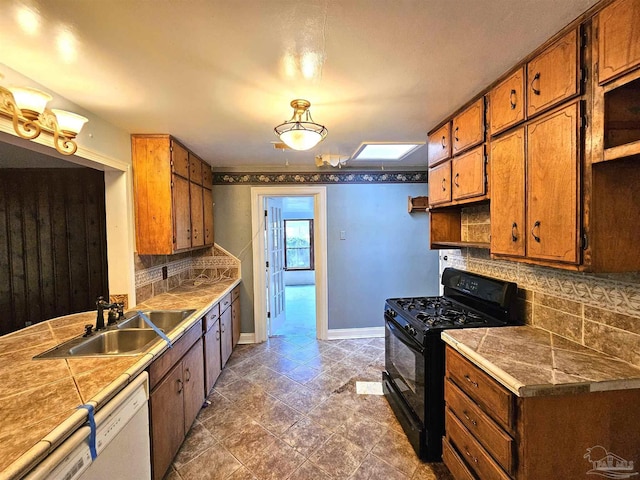 kitchen with black gas range, sink, white dishwasher, and tasteful backsplash