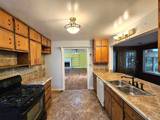 kitchen featuring sink, black gas range oven, dishwasher, ceiling fan, and backsplash