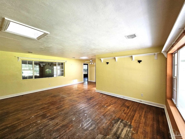 spare room featuring wood-type flooring, ceiling fan, and a textured ceiling