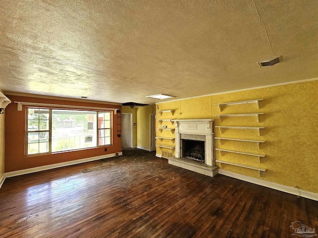 unfurnished living room featuring crown molding, a premium fireplace, a textured ceiling, dark hardwood / wood-style flooring, and built in shelves