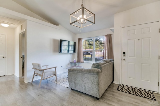 foyer entrance with light wood finished floors, baseboards, visible vents, lofted ceiling, and an inviting chandelier