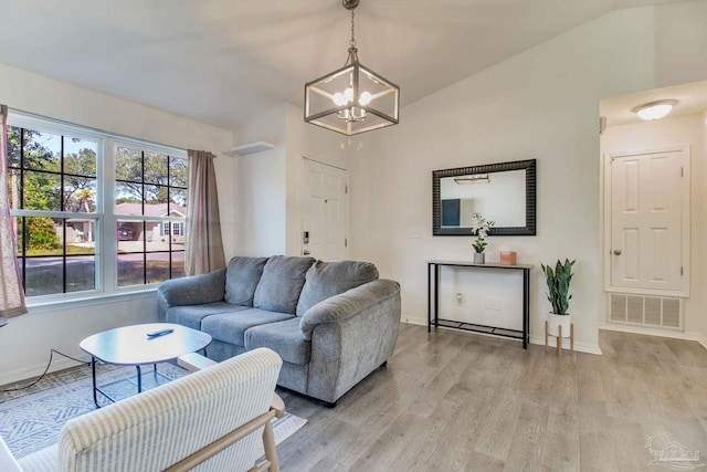 living area with light wood-style floors, baseboards, visible vents, and vaulted ceiling