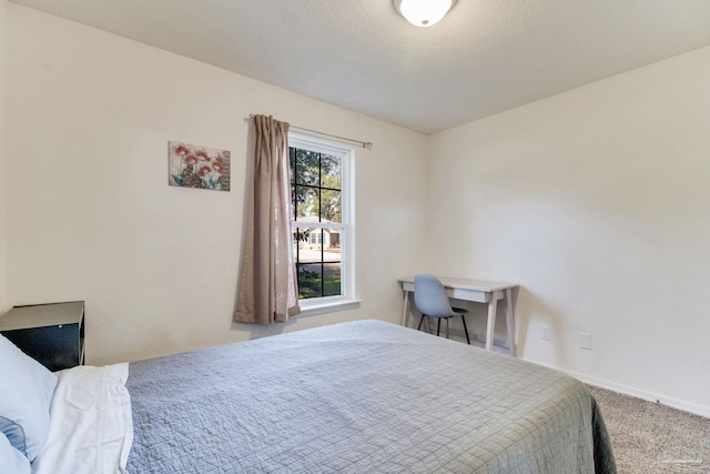 carpeted bedroom featuring baseboards and a textured ceiling