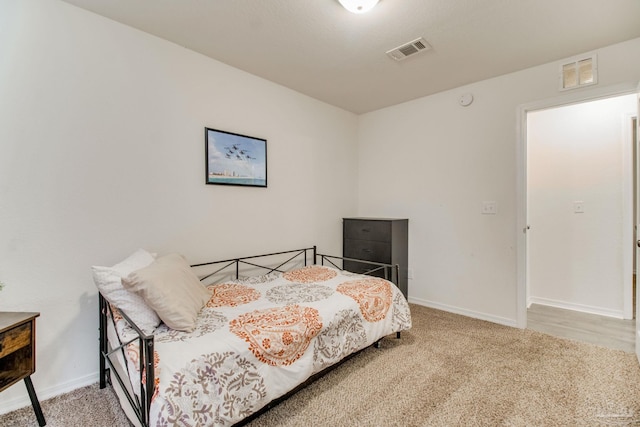 carpeted bedroom with baseboards and visible vents