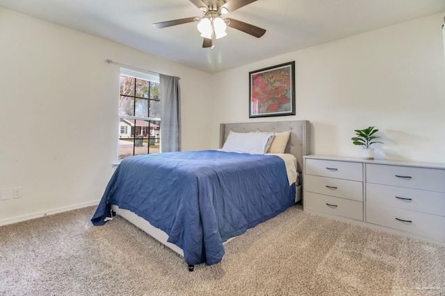 bedroom with light colored carpet, ceiling fan, and baseboards