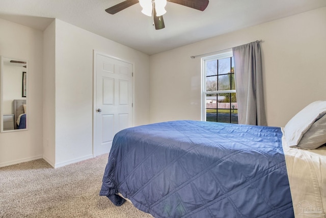 bedroom with a ceiling fan, baseboards, and carpet flooring