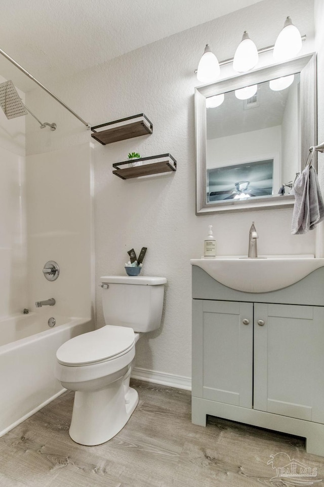 bathroom with visible vents, toilet, tub / shower combination, vanity, and wood finished floors