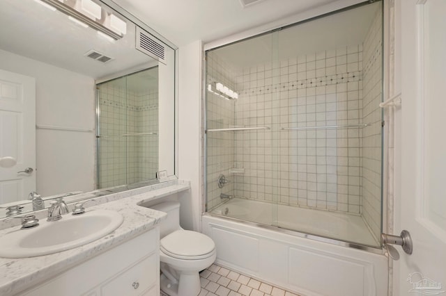 full bathroom with toilet, bath / shower combo with glass door, vanity, and tile patterned floors