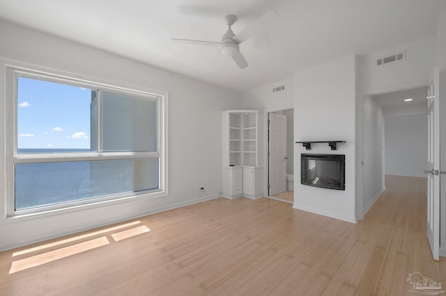 unfurnished living room featuring ceiling fan and light hardwood / wood-style flooring