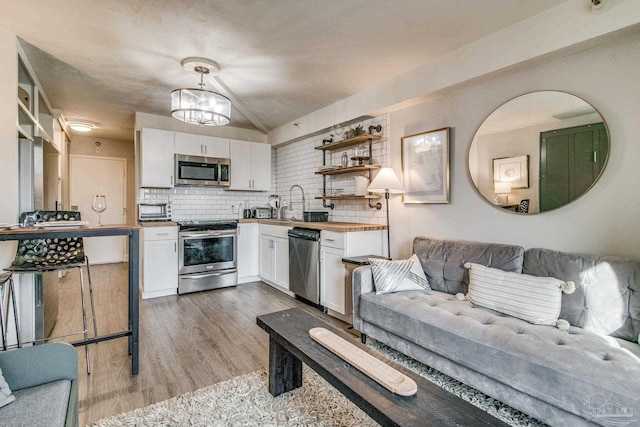 224 E Garden St Unit 236, Pensacola, FL 32502 - kitchen with pendant lighting, stainless steel appliances, light hardwood / wood-style flooring, and white cabinets