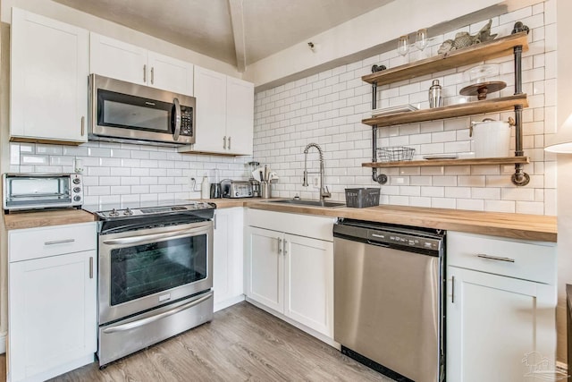 224 E Garden St Unit 236, Pensacola, FL 32502 - kitchen featuring white cabinetry, sink, wooden counters, and appliances with stainless steel finishes