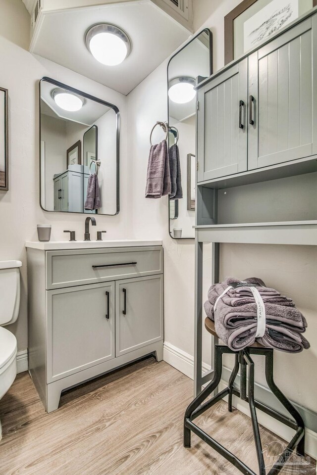 224 E Garden St Unit 236, Pensacola, FL 32502 - bathroom featuring vanity, toilet, and hardwood / wood-style floors