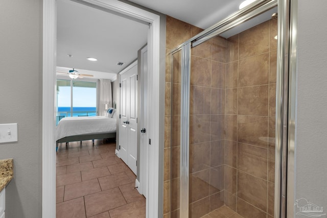 bathroom featuring tile patterned floors, walk in shower, vanity, ceiling fan, and a water view