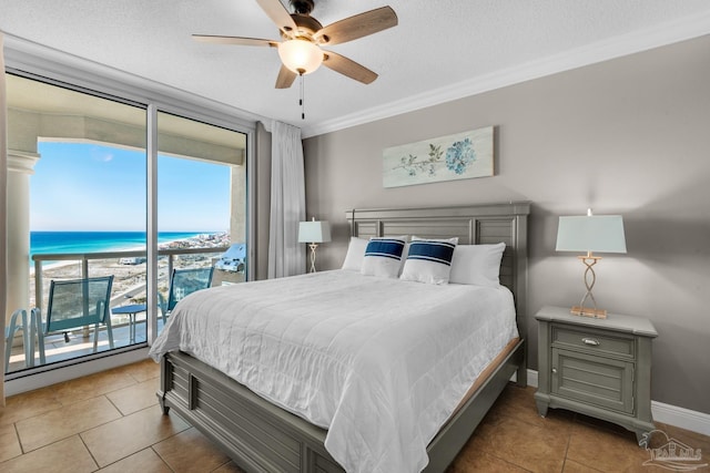 tiled bedroom featuring access to exterior, ceiling fan, a water view, and multiple windows