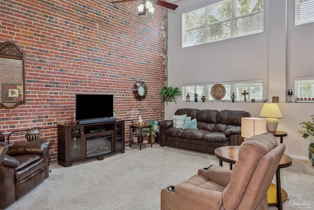 carpeted living room featuring a towering ceiling and ceiling fan