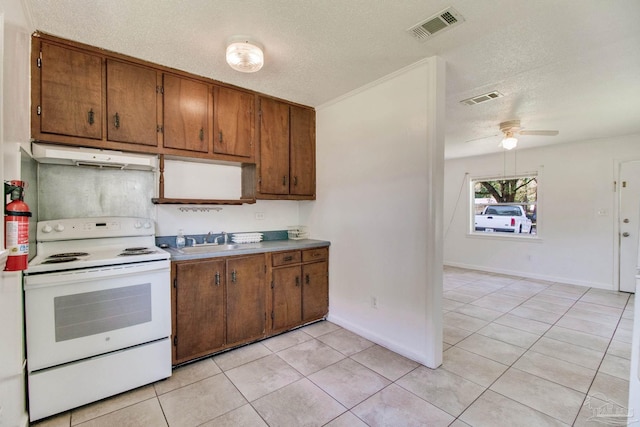 kitchen featuring white electric range oven, visible vents, under cabinet range hood, and brown cabinets