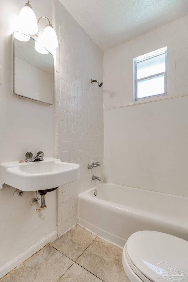 bathroom featuring tile patterned flooring, toilet, and tub / shower combination