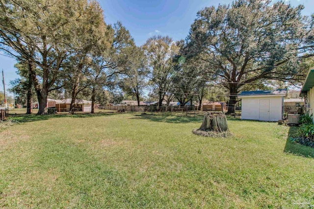 view of yard with a storage shed, a fenced backyard, and an outdoor structure