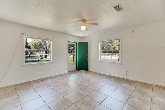 spare room featuring light tile patterned floors, visible vents, baseboards, and ceiling fan