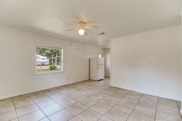 unfurnished room featuring visible vents, baseboards, light tile patterned floors, a textured ceiling, and a ceiling fan