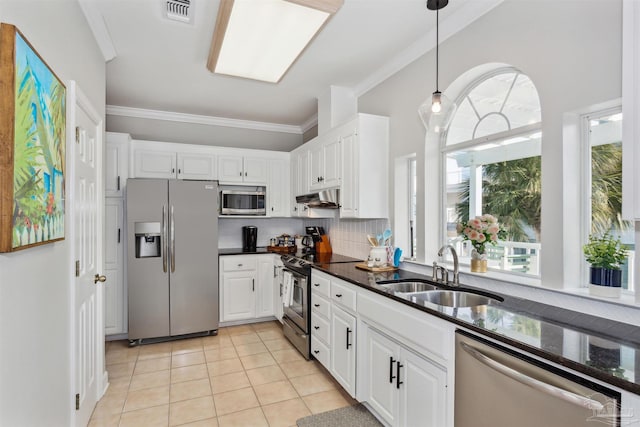 kitchen with white cabinetry, sink, dark stone counters, light tile patterned flooring, and appliances with stainless steel finishes