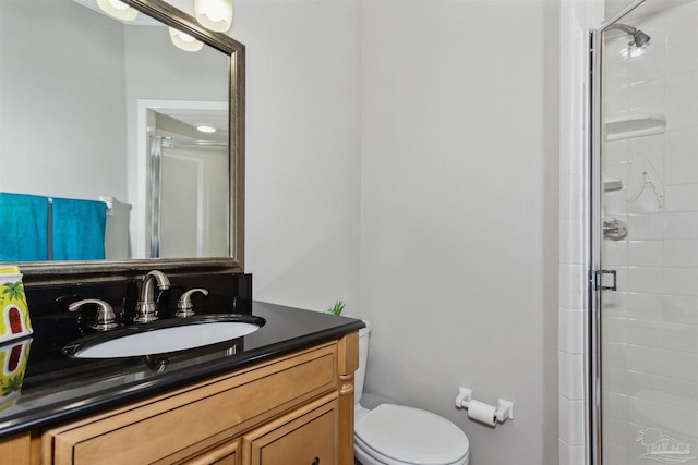 bathroom with vanity, toilet, and a shower with door