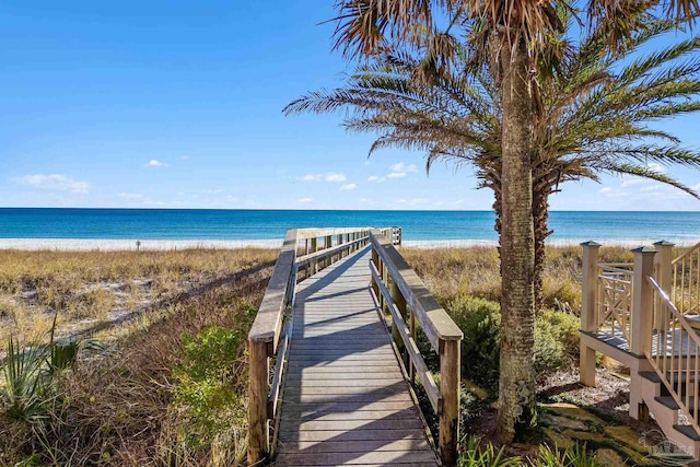 view of property's community with a water view and a beach view