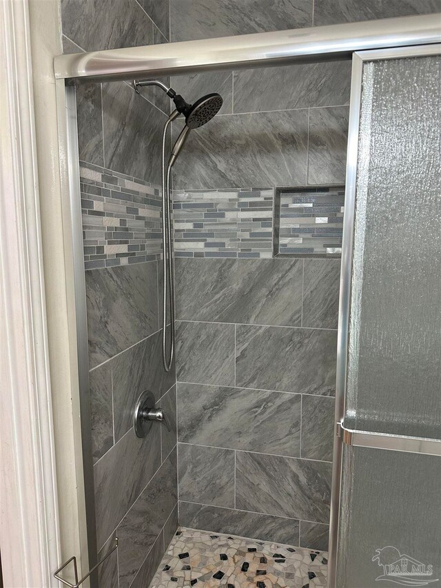 bathroom with a shower with door