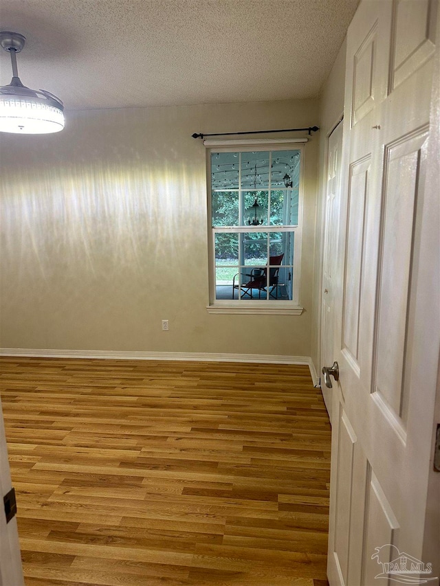 empty room with a textured ceiling and hardwood / wood-style floors